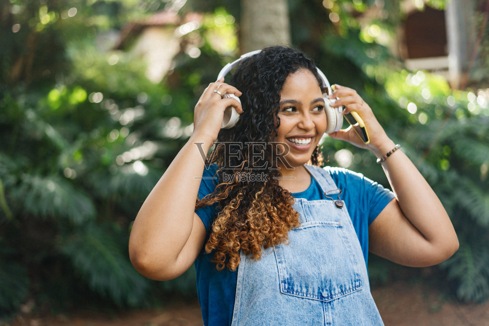 微笑的女人把耳机放在户外照片摄影图片