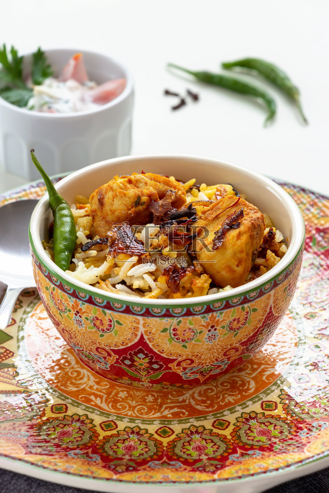 传统印度鸡肉印度饭或阿拉伯kabsa与藏红花酸奶番茄raita。正宗的印度菜。白色背景。有选择性的重点。照片摄影图片