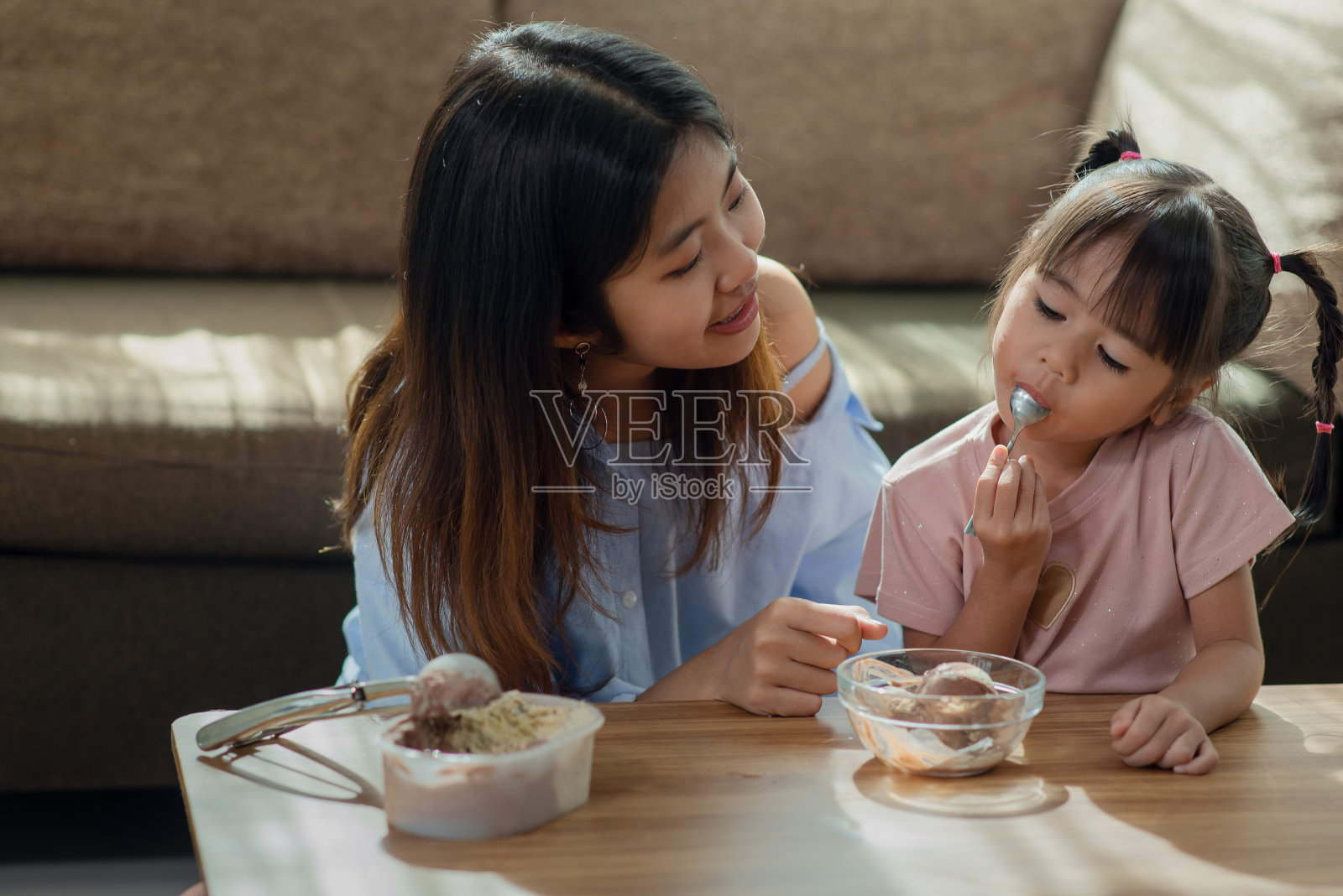 快乐的亚洲孩子喜欢和她的姐姐吃冰淇淋照片摄影图片