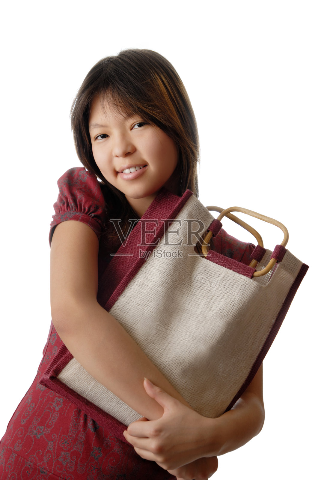 十几岁的女孩拿着一个可重复使用的购物袋，背景是白色的照片摄影图片