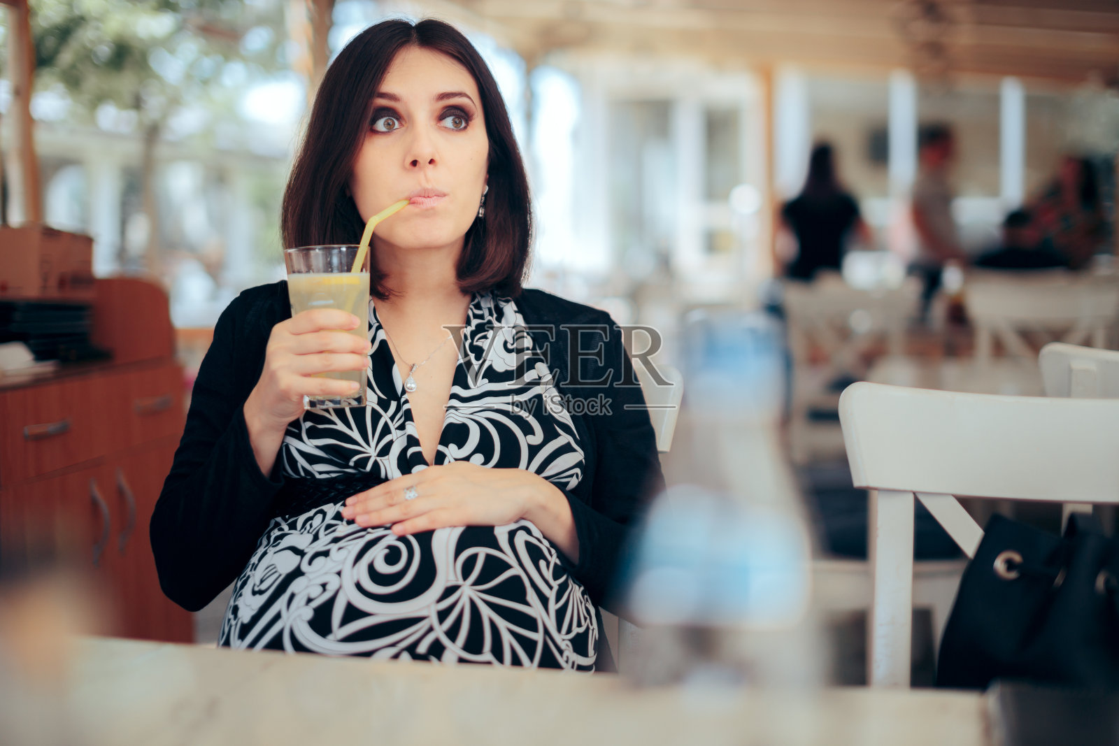 孕妇在餐厅喝柠檬水照片摄影图片