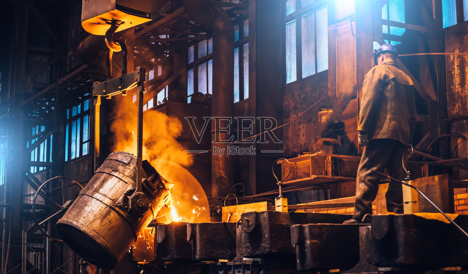 液态金属倒入模具中。在重工业铸造冶金厂的熔炉中熔化金属照片摄影图片