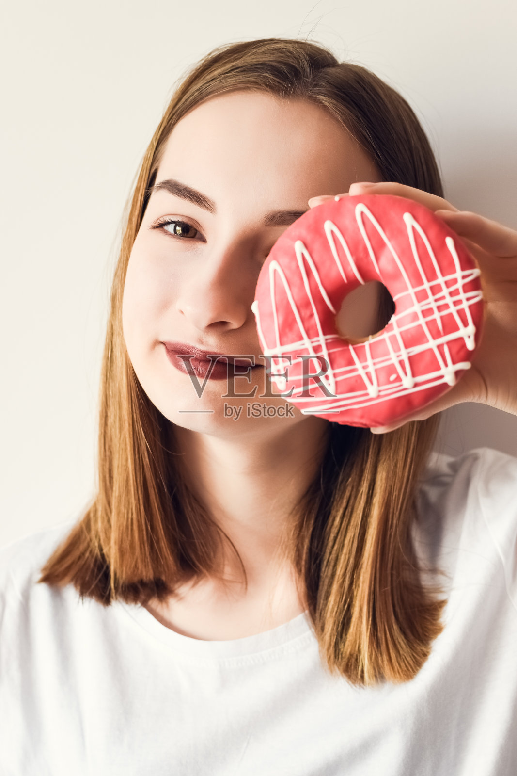 漂亮女孩拿着甜甜圈玩得很开心照片摄影图片
