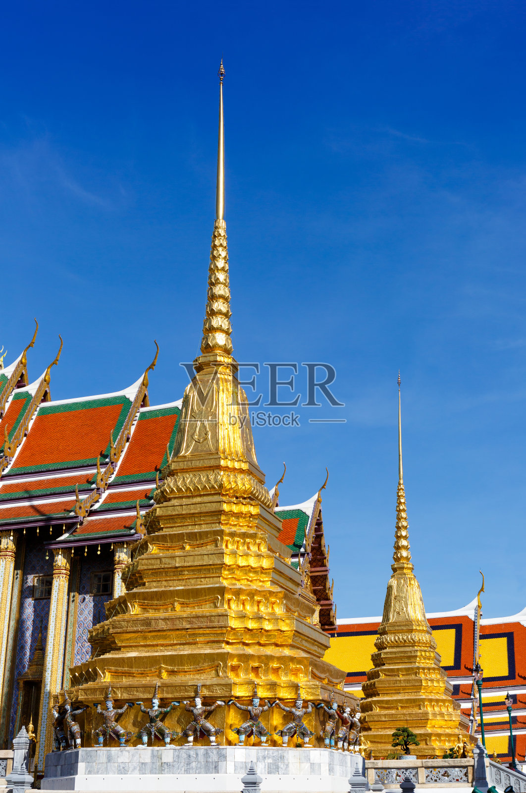 金塔与恶魔守卫在佛寺或翡翠佛寺在曼谷，泰国大皇宫的庭园内照片摄影图片