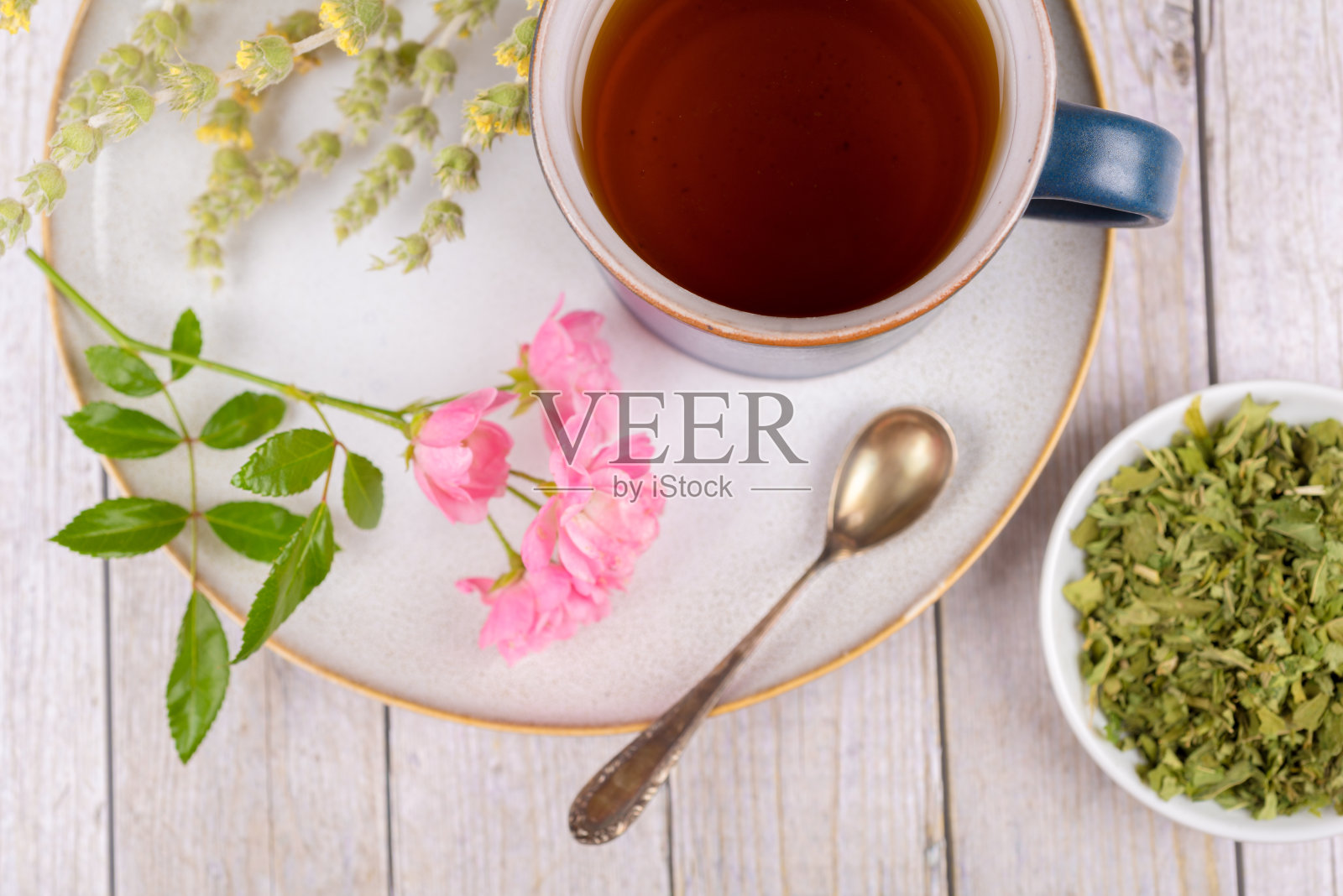 绿茶或花草茶，用杯子，盘子和干草药照片摄影图片
