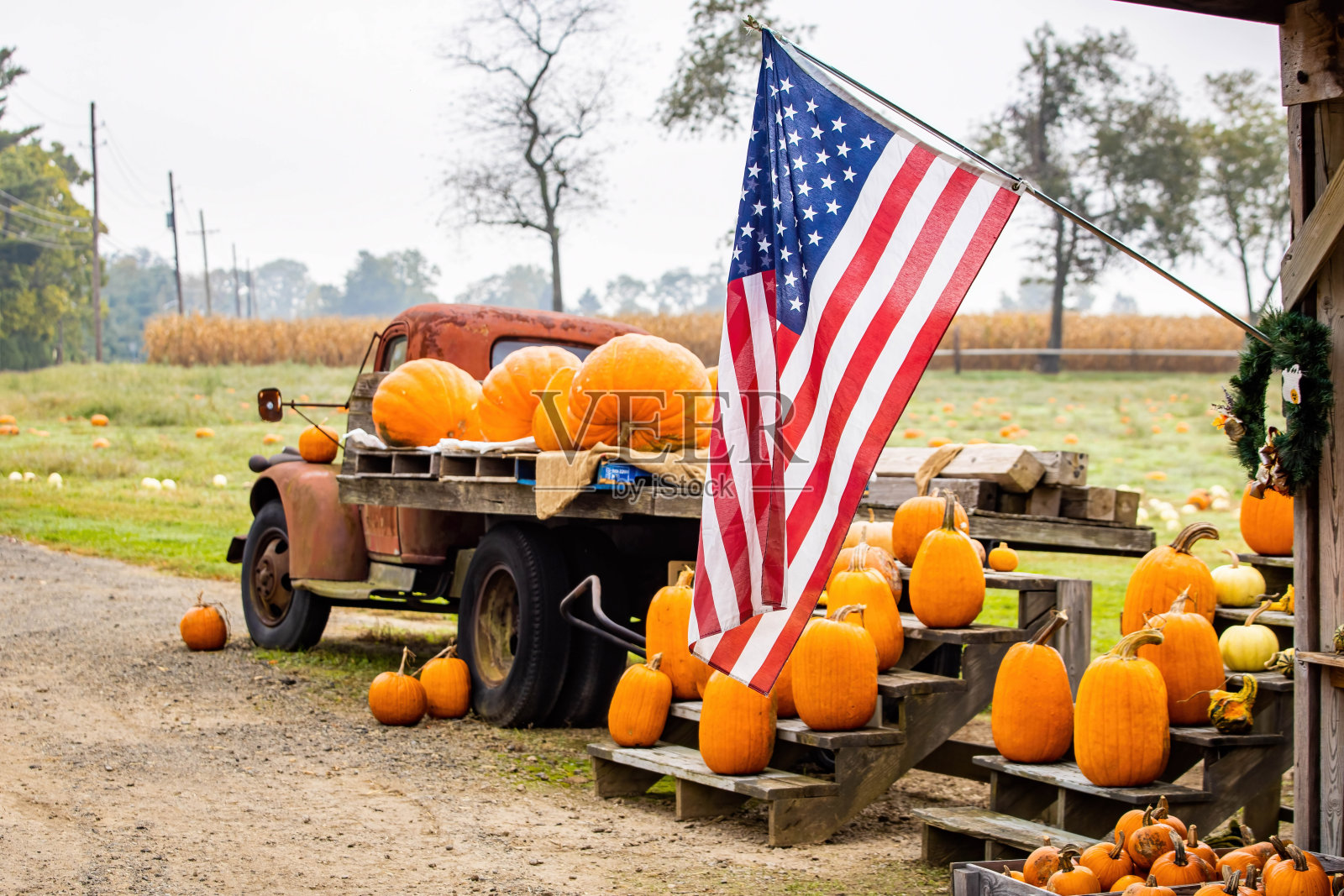 在秋天用美国国旗农民标志装南瓜的卡车照片摄影图片