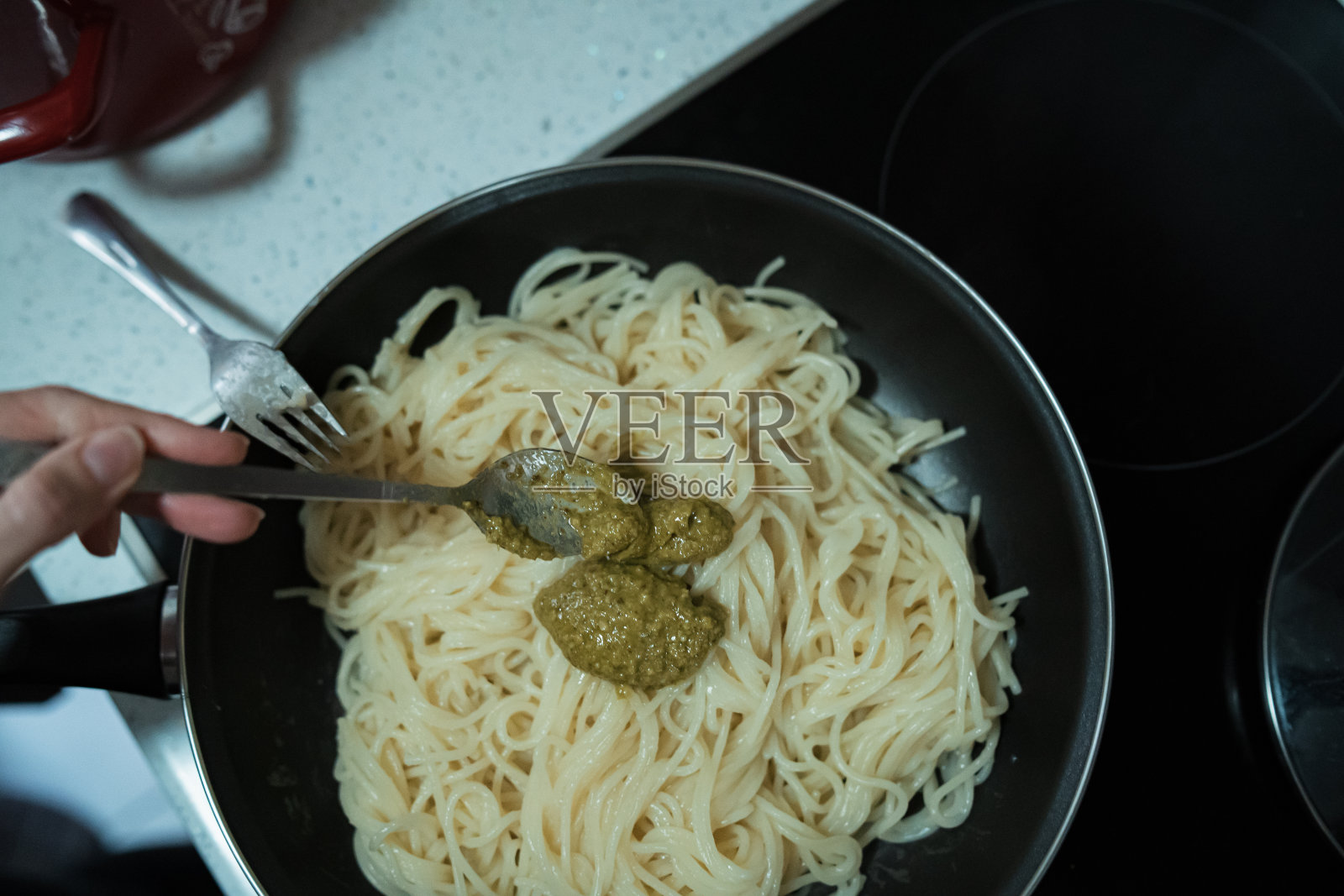 一位妇女在自家厨房里做香蒜酱意面照片摄影图片