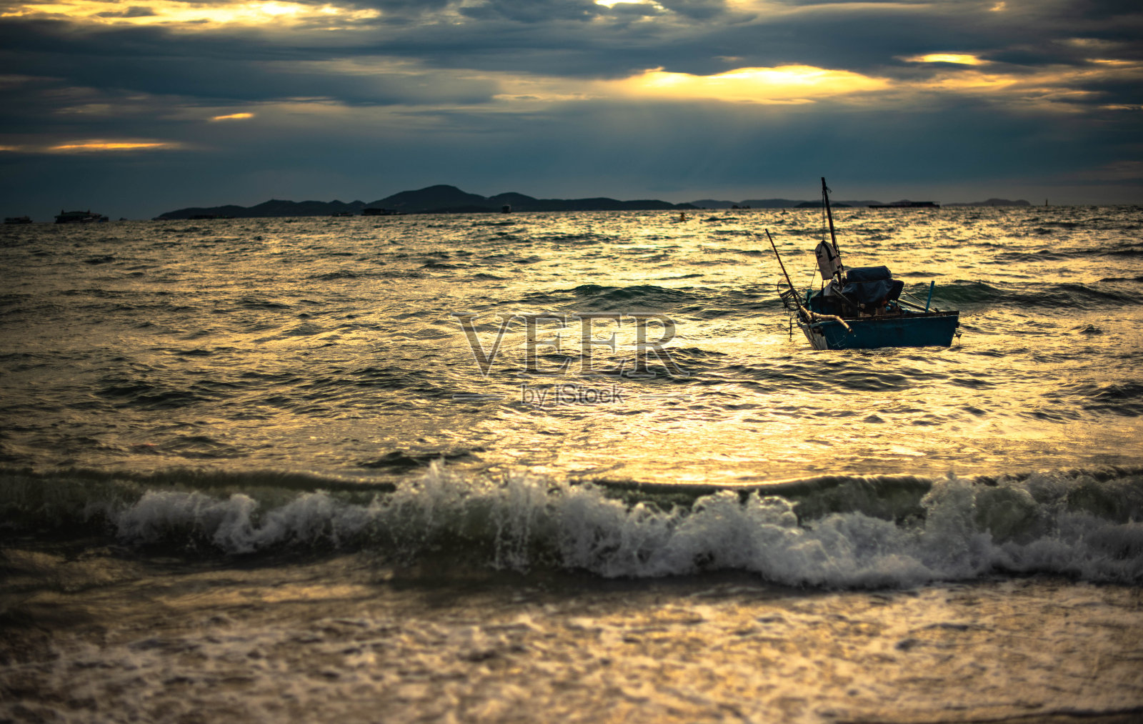 晚上，当地渔船停泊在芭堤雅海滩。照片摄影图片