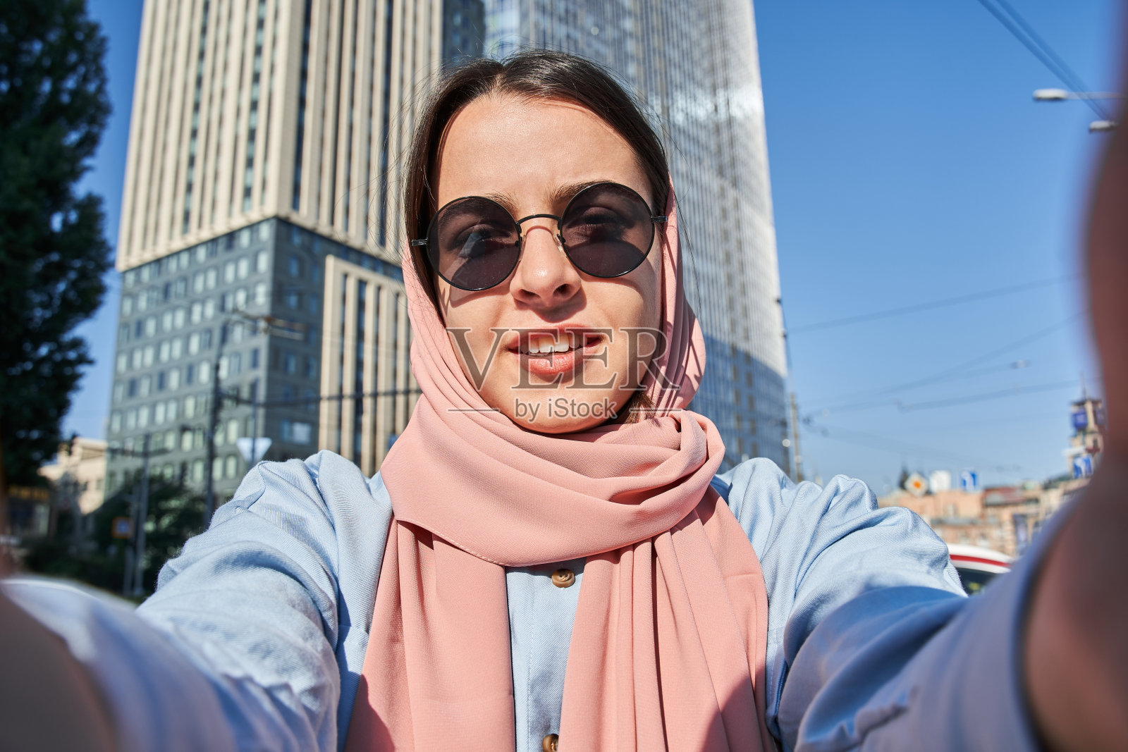 冷静的伊斯兰妇女站着，微笑着在视频通话中告诉一些事情照片摄影图片