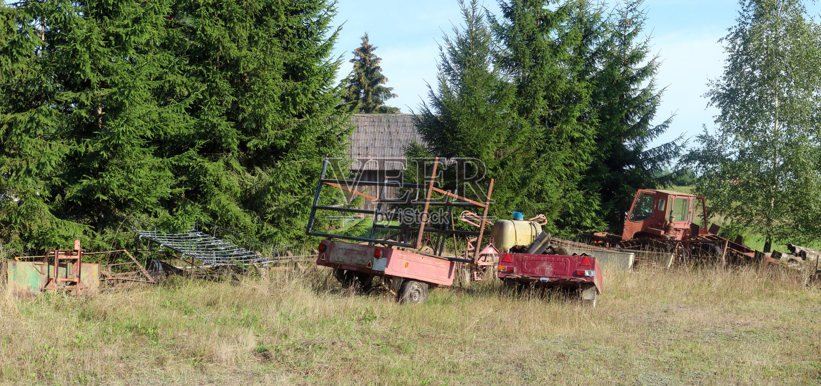 残破生锈的旧农业机械留在森林里照片摄影图片
