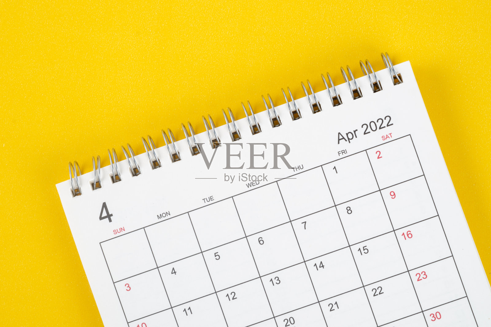 4月，2022年日历桌，供组织者规划和提醒在黄色背景。照片摄影图片