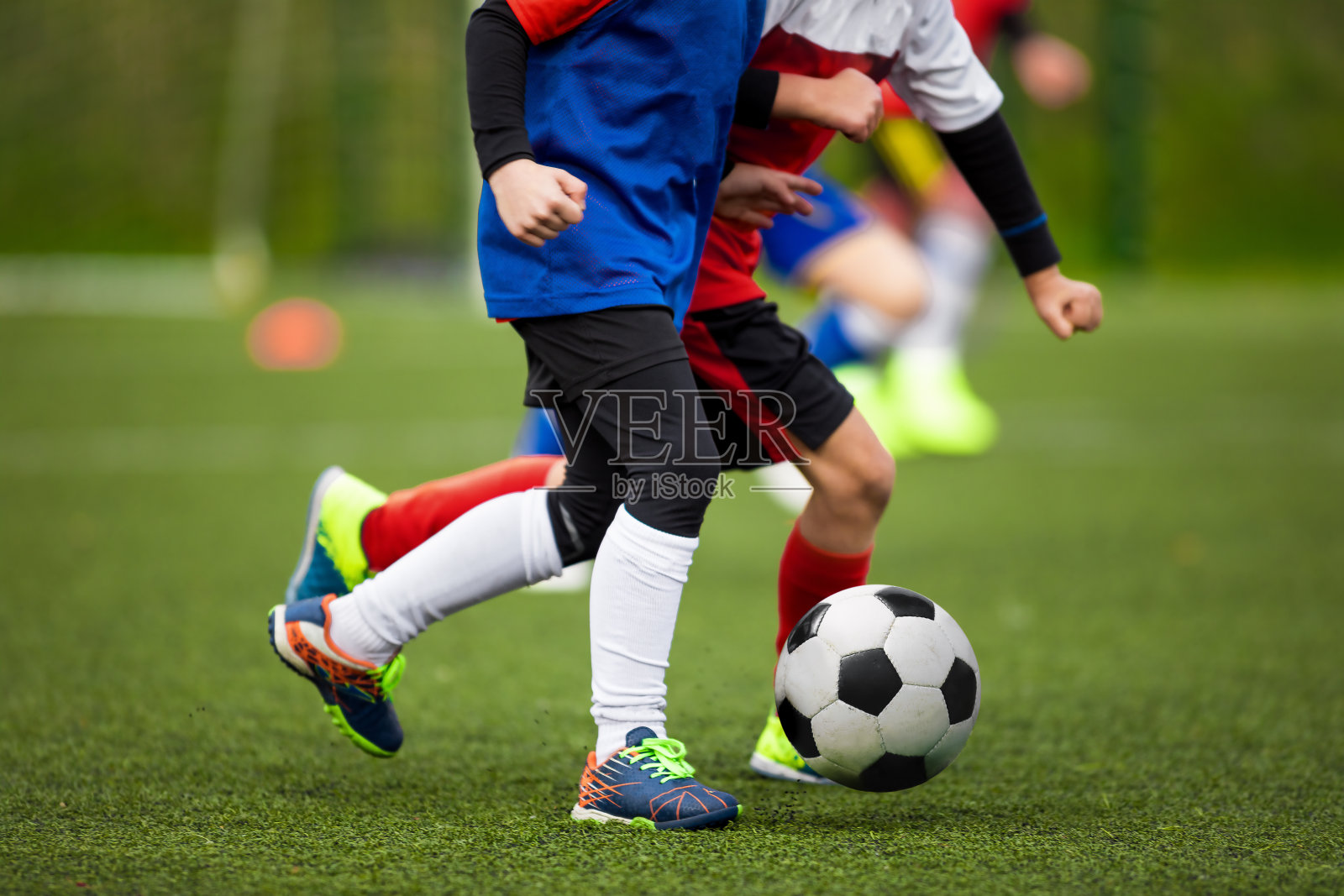 孩子们在草地上踢足球。两个学校的孩子在足球比赛中进行决斗和竞争照片摄影图片