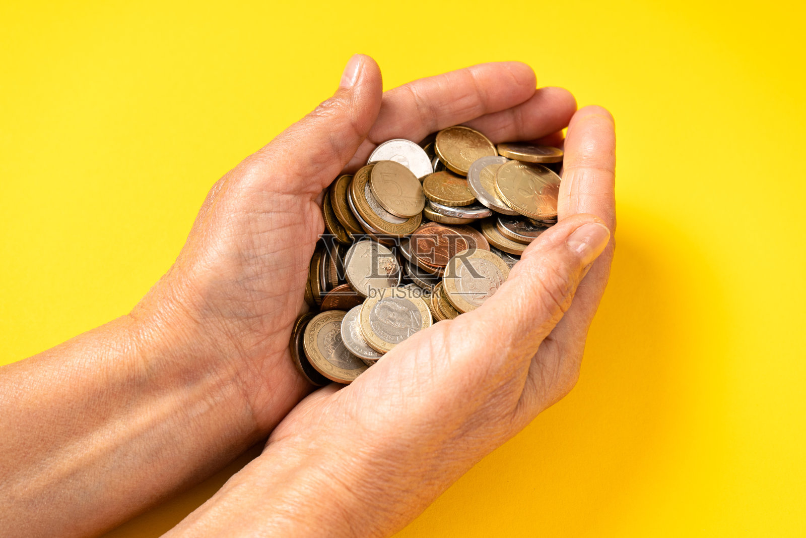 退休，老太太的积蓄。一位老妇人手里有很多硬币。近距离照片摄影图片