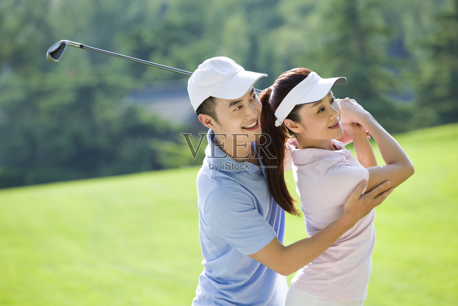 年轻男子教女朋友打高尔夫球照片摄影图片
