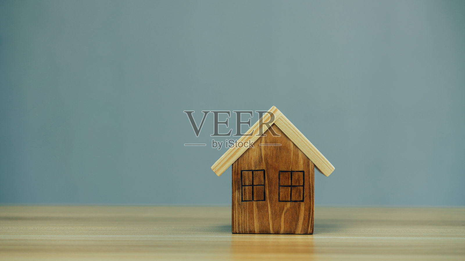 桌子背景上的房子木模型。照片摄影图片