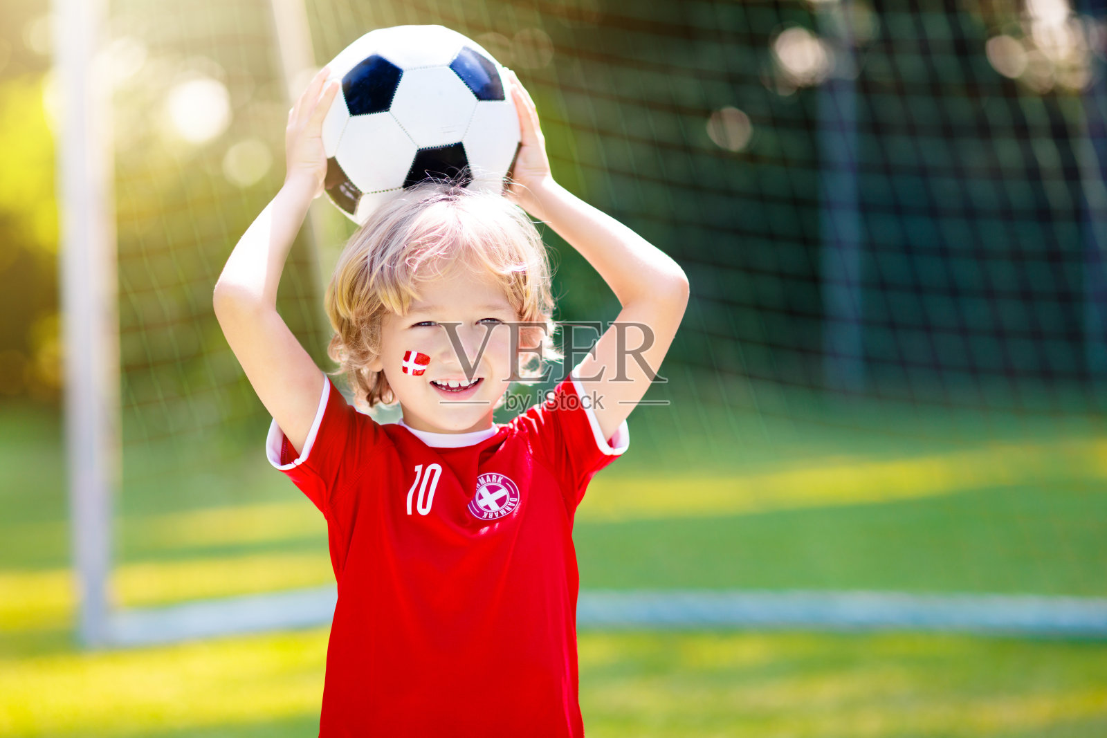 丹麦球迷。丹麦孩子踢足球。照片摄影图片
